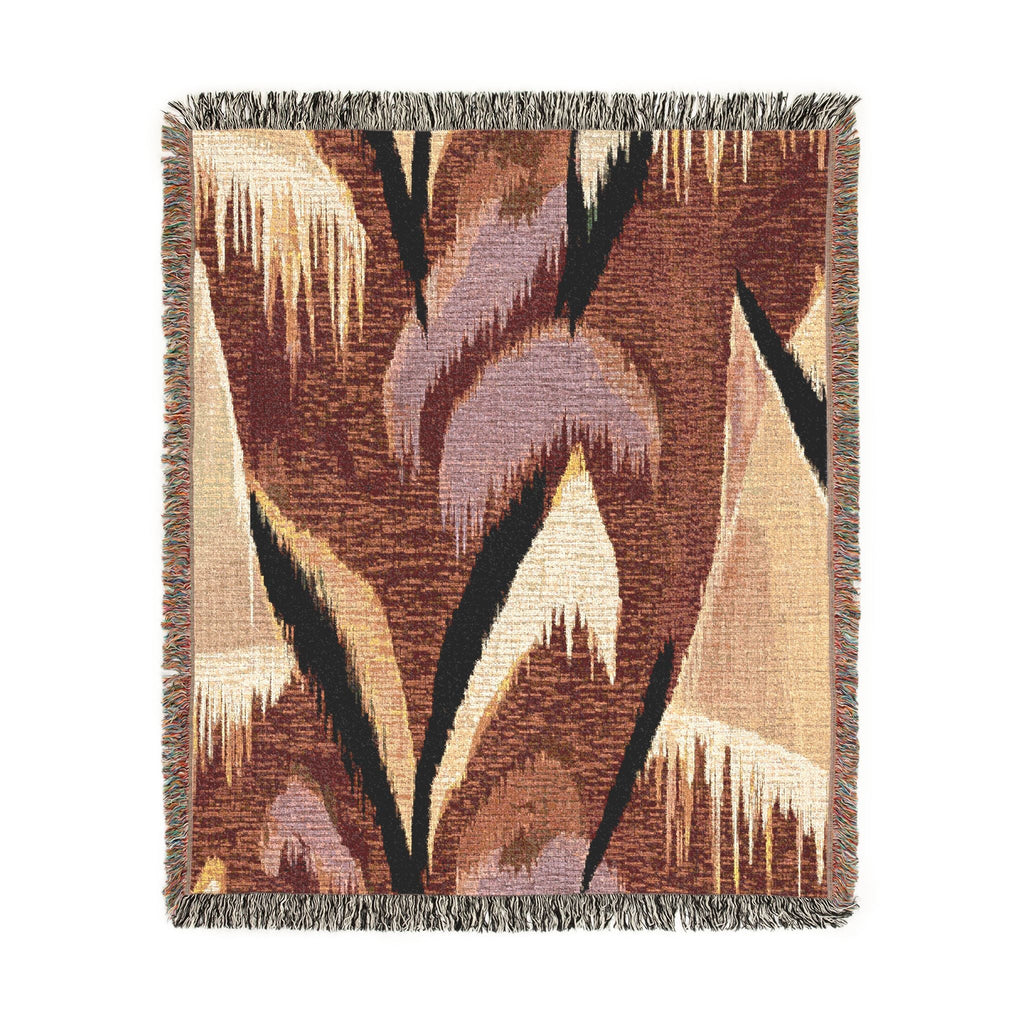 A square woven throw blanket with a geometric ikat pattern in brown, beige, black, and muted purple, finished with fringed edges.