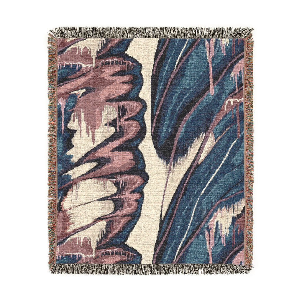 A square woven throw blanket with fringed edges, featuring an abstract botanical pattern in navy blue, dusty pink, and cream.